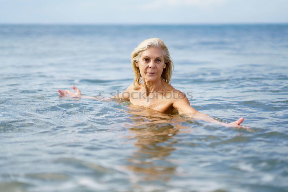 Foto Bild Reife Frau in guter Form beim Baden im Meer.