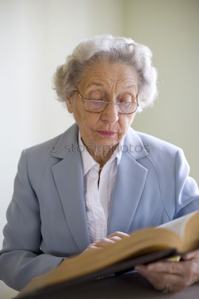 Similar – Image, Stock Photo Elderly woman wearing glasses sitting in her living room reading a letter, closeup portrait