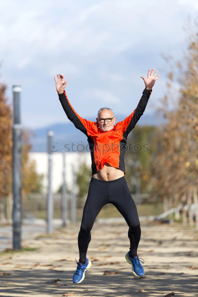 Senior runner man jumping arms up after running