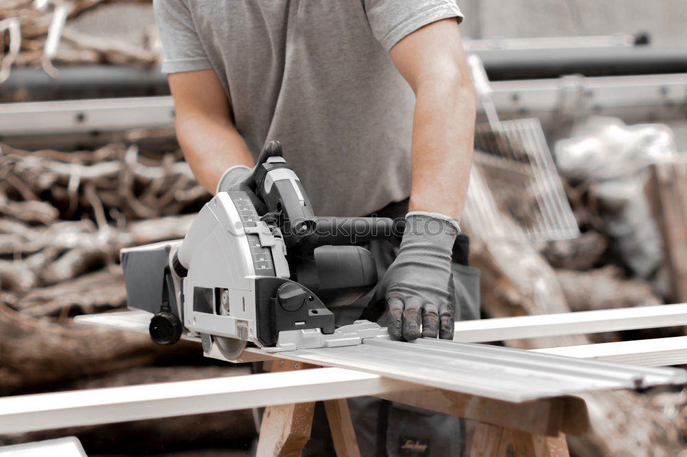 Similar – Carpenter with circular saw cutting a wooden.