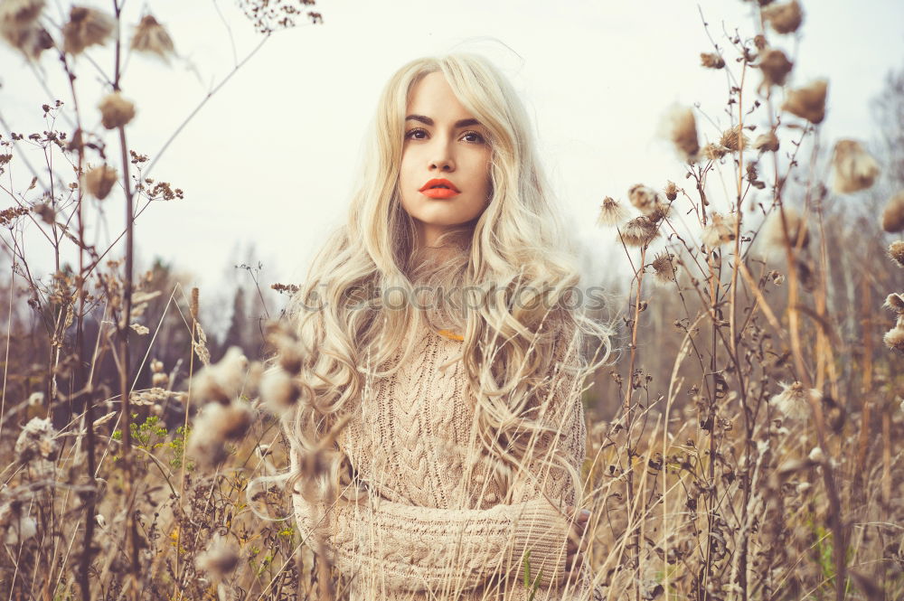 Similar – Young woman observing weird flowers