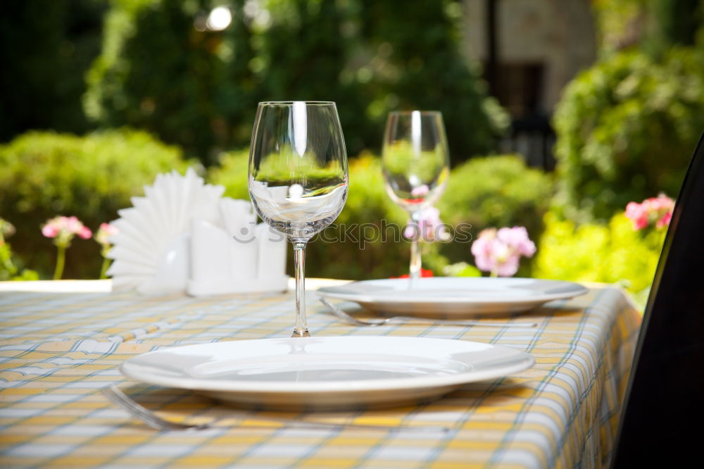 Bottle of red wine and table set on the veranda