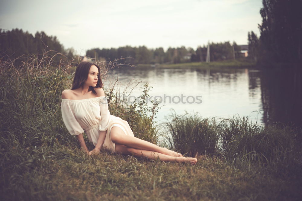 Image, Stock Photo analog medium format portrait of young woman in summer dress sitting barefoot among bushes in nature on a lakeside