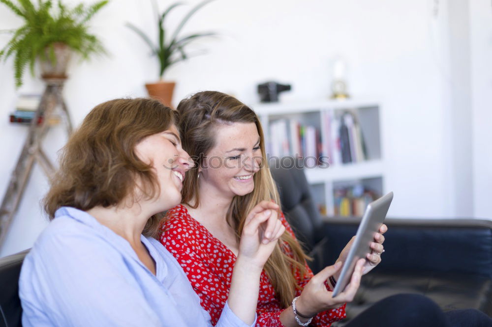 Similar – Image, Stock Photo Overhead photograph of two beautiful young women at home sitting on sofa while using a tablet PC computer and smiling