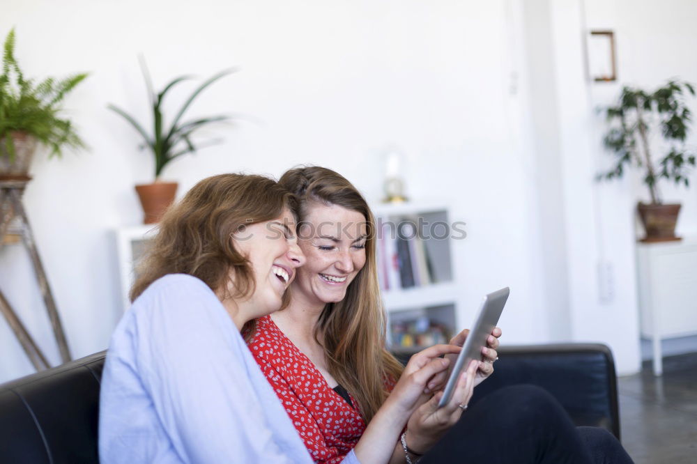 Image, Stock Photo Overhead photograph of two beautiful young women at home sitting on sofa while using a tablet PC computer and smiling