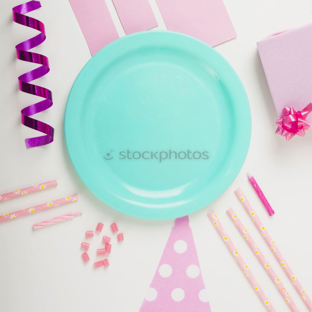 Disposable colorful plastic dish, straws and cups, cutlery. Flat lay on pink background.