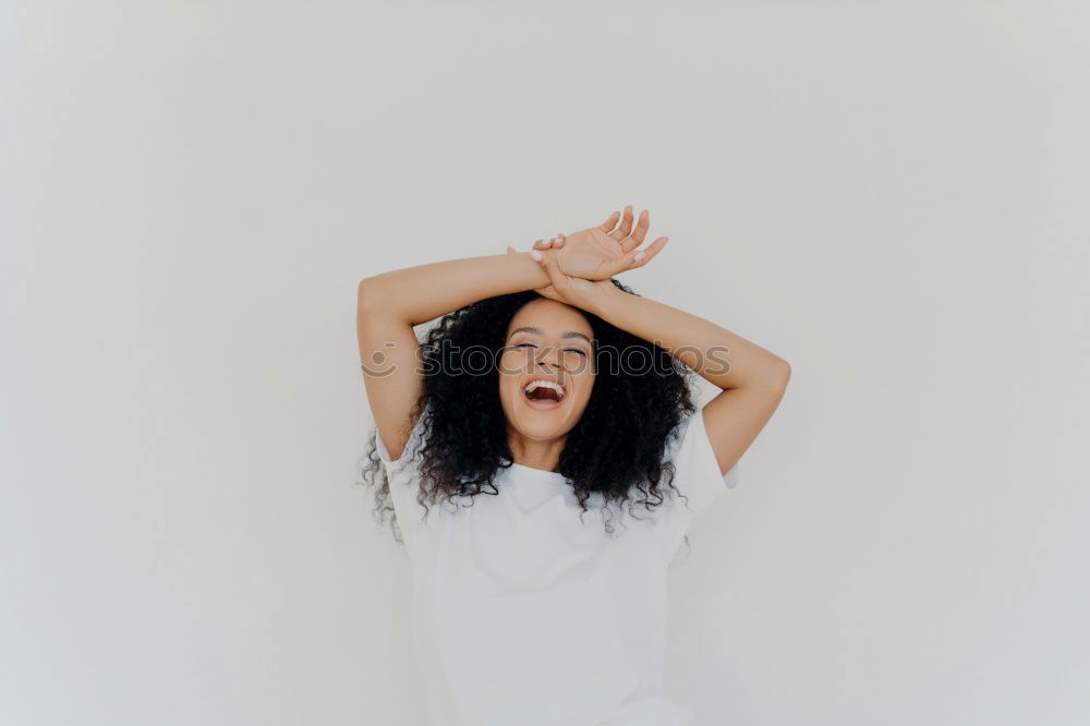 Young woman leaning on white wall