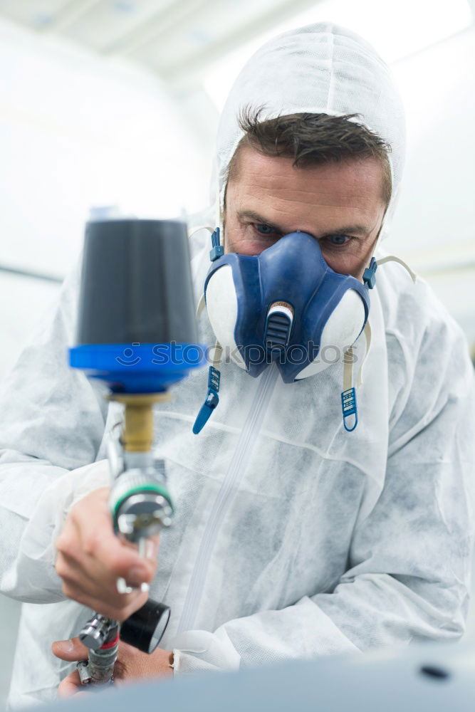 Similar – Man with a dust mask and goggles working on a circular saw