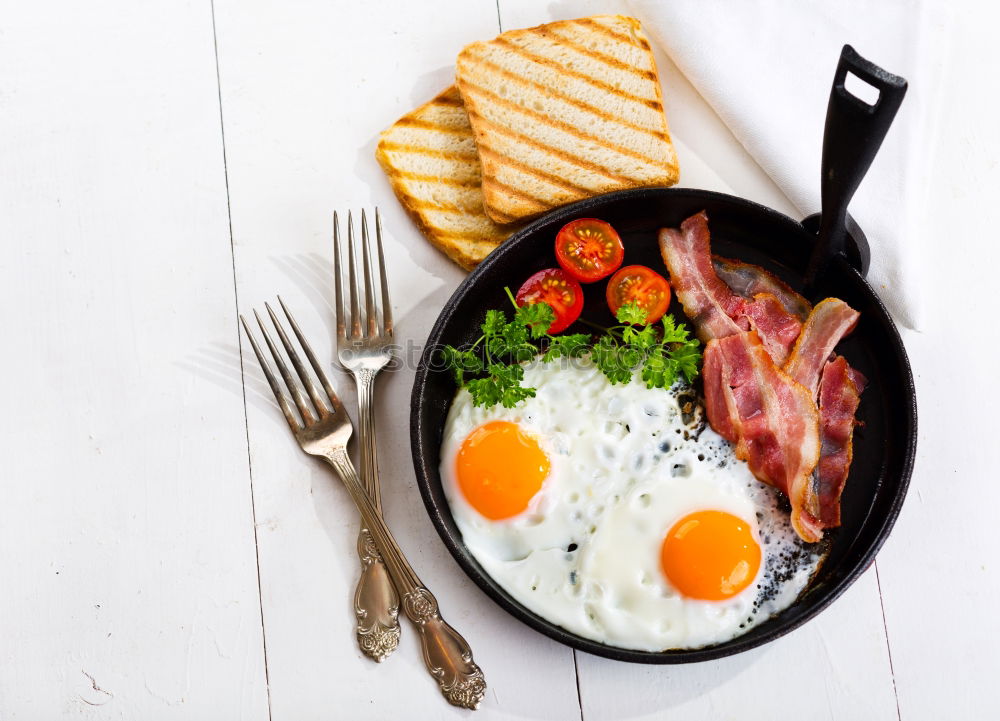 Similar – Fried egg with tomatoes and herbs on a old frying pan