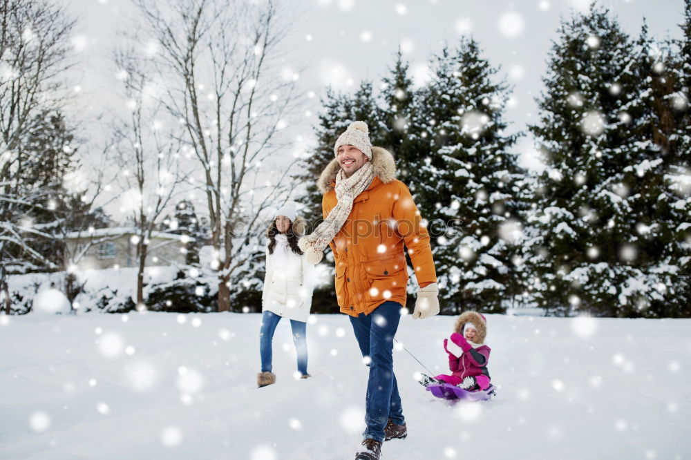 Teenage girl enjoying snow with her little sister. Children are walking through deep snow while snow falling, enjoying wintertime. Sisters spending time together. Girls are wearing winter clothes, young girl is wearing pink coat and wool cap