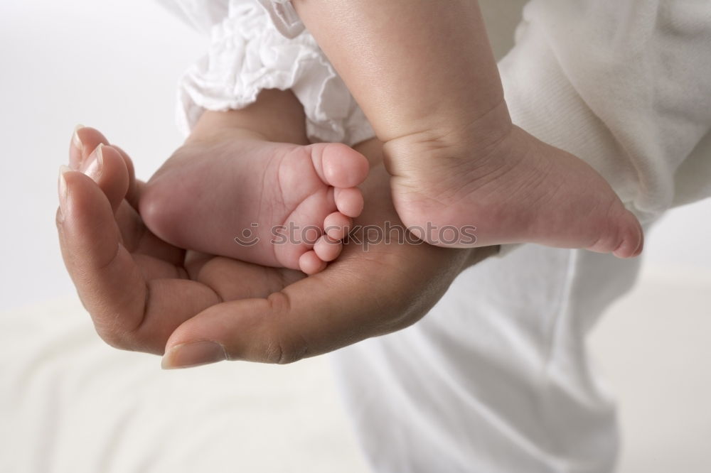 Similar – Image, Stock Photo Parents hands holding feet of newborn lying over bed