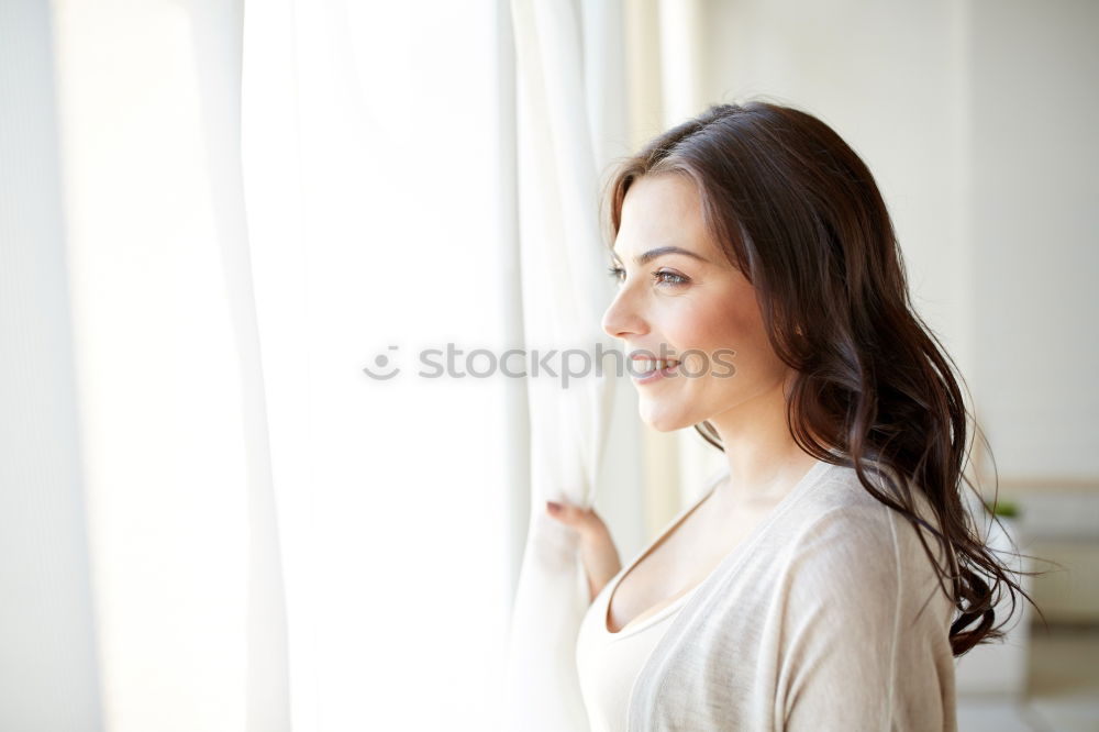 Similar – Young thoughtful woman looking through the window