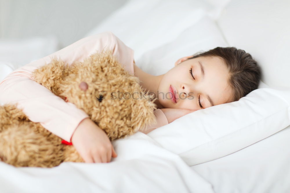 Similar – Little girl lying in a bed with teddy bear at the morning