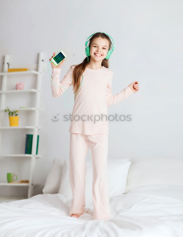 beautiful kid girl jumping on bed