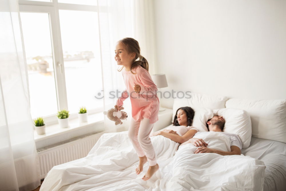 Similar – Three sisters playing with each other lying down in bed at home listening to music