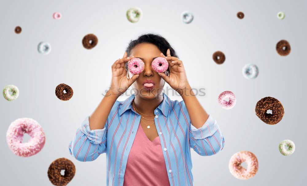 Similar – Young woman pulling funny face holding donuts in hands