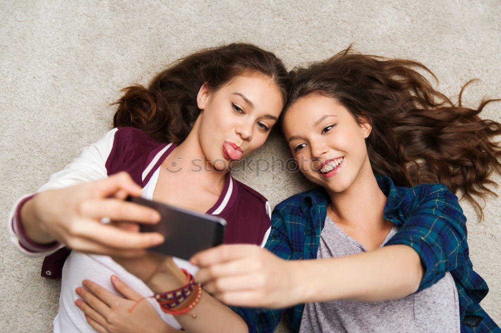 Similar – Image, Stock Photo Young women using mobile phones watching music clip, texting, messaging. Teenagers using the smartphones, sitting on sofa at home. Using technology devices. Girls wearing summer clothing