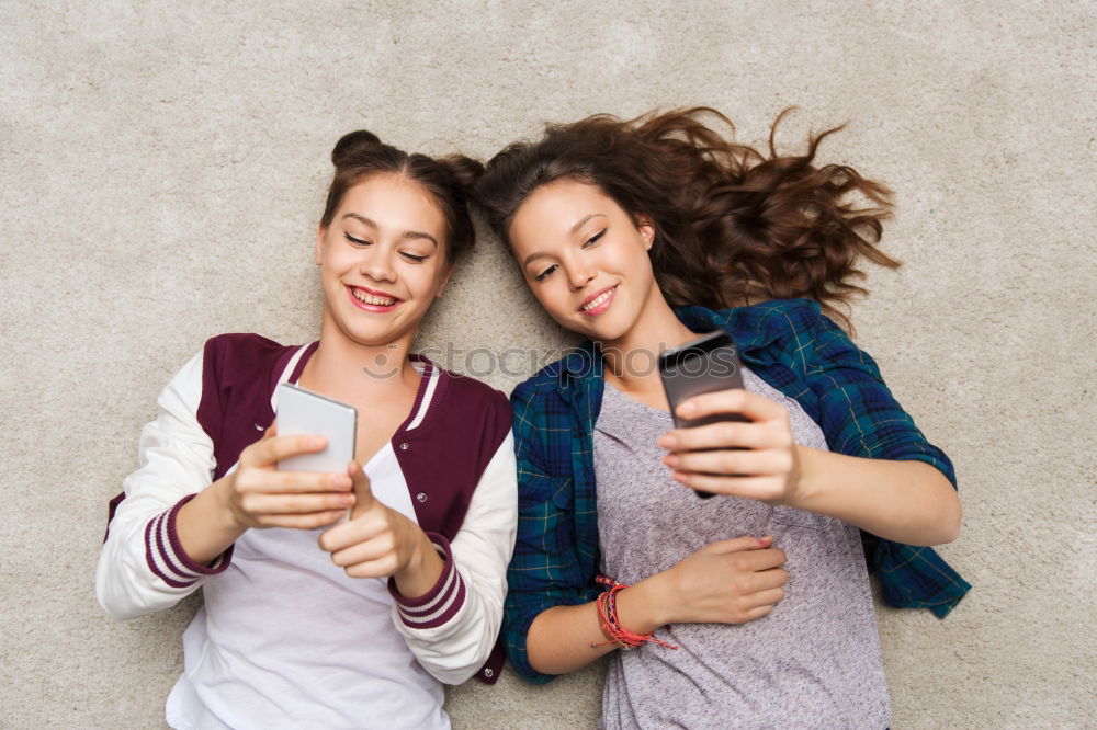 Similar – Image, Stock Photo Young women using mobile phones watching music clip, texting, messaging. Teenagers using the smartphones, sitting on sofa at home. Using technology devices. Girls wearing summer clothing