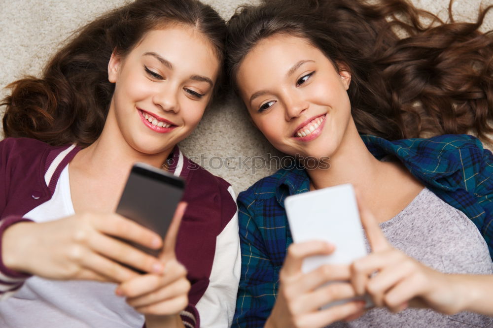 Similar – Image, Stock Photo Young women using mobile phones watching music clip, texting, messaging. Teenagers using the smartphones, sitting on sofa at home. Using technology devices. Girls wearing summer clothing