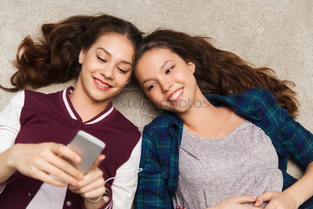 Similar – Image, Stock Photo Young women using mobile phones watching music clip, texting, messaging. Teenagers using the smartphones, sitting on sofa at home. Using technology devices. Girls wearing summer clothing