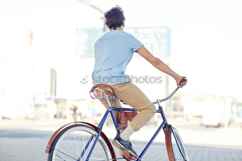 Similar – Young man riding bicycle and listening to music in headphones on city street