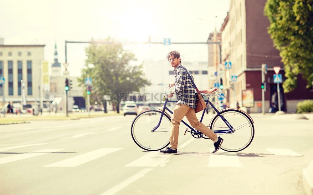 Similar – Young modern hipster riding bike trough urban city while sunset