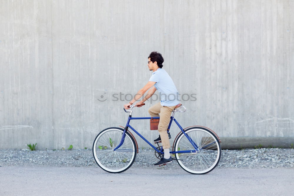 Similar – Young man riding bicycle and listening to music in headphones on city street