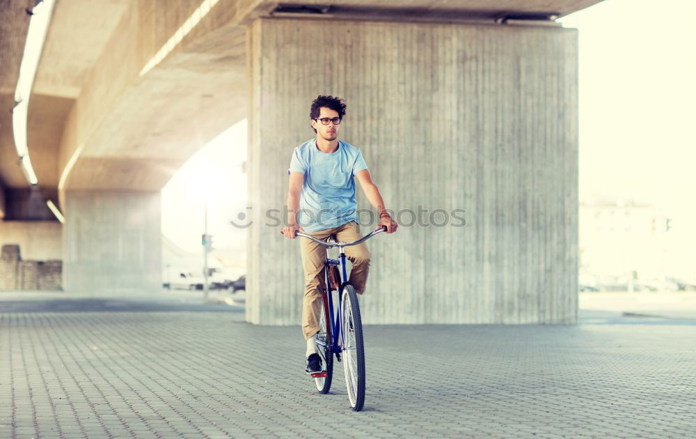 Similar – Stylish urban businessman standing on the street with bicycle