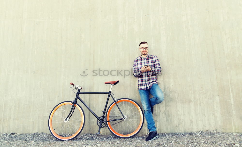 Similar – Stylish urban businessman standing on the street with bicycle