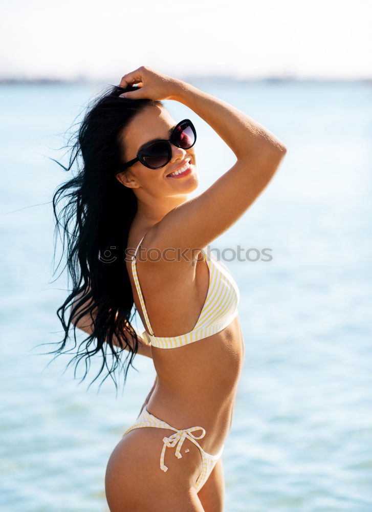 Similar – Young arabic woman with beautiful body in swimwear smiling on a tropical beach.