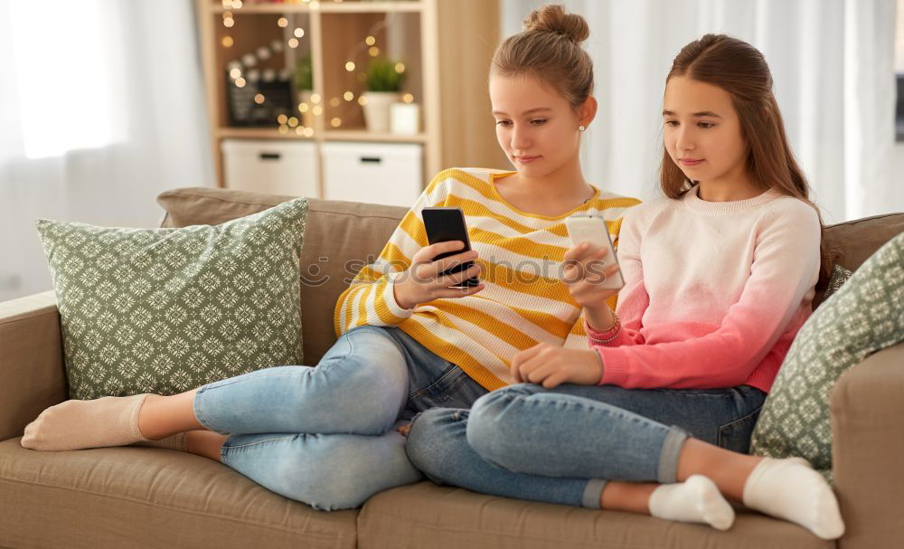 Similar – Image, Stock Photo Young women using mobile phones watching music clip, texting, messaging. Teenagers using the smartphones, sitting on sofa at home. Using technology devices. Girls wearing summer clothing