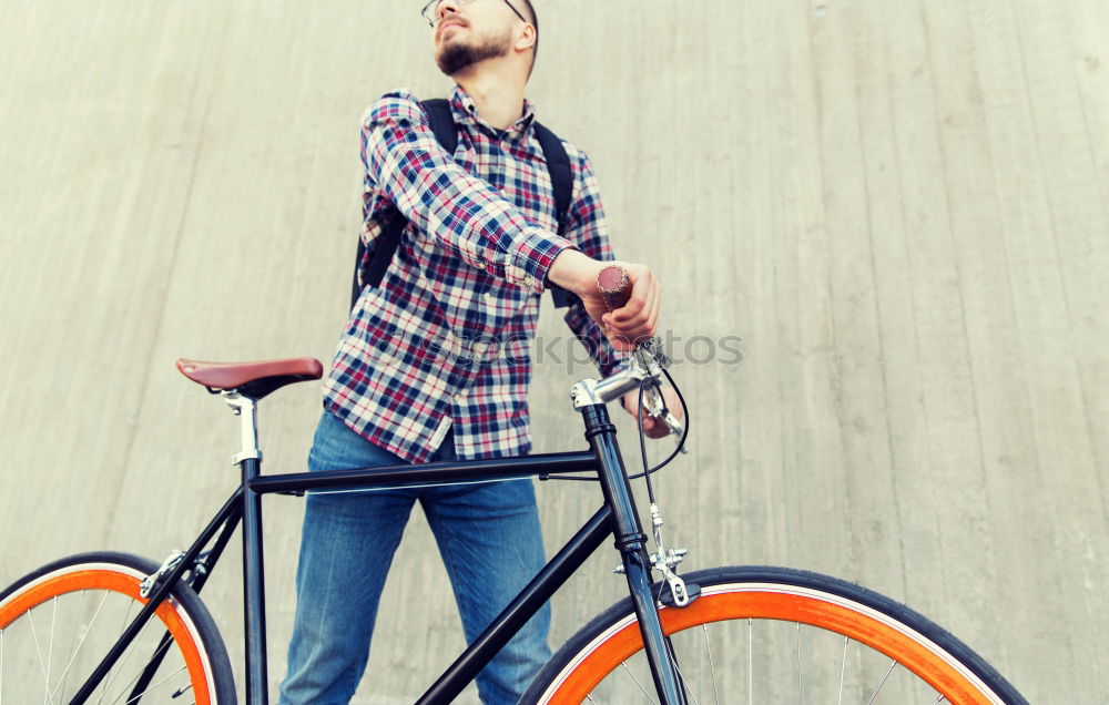 Similar – Young man riding bicycle and listening to music in headphones on city street