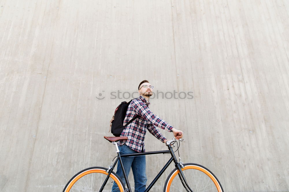 Similar – Young man riding bicycle and listening to music in headphones on city street