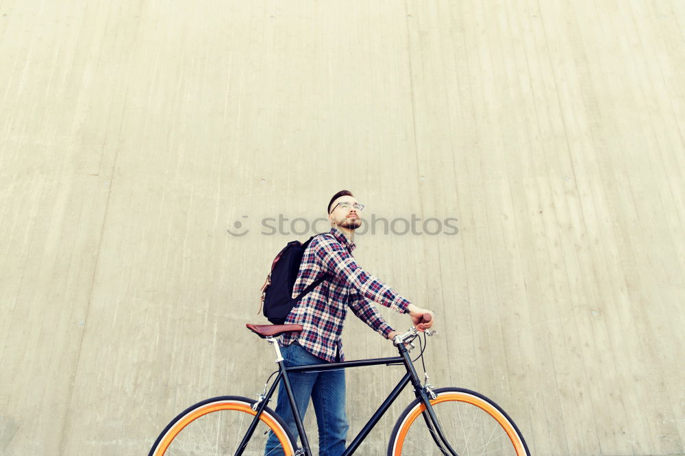 Similar – Stylish urban businessman standing on the street with bicycle