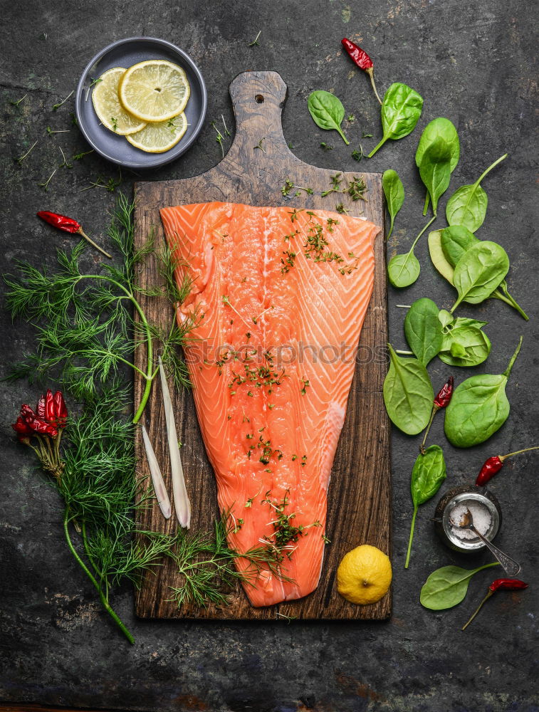 Similar – Salmon fish fillets on chopping board with fresh vegetables