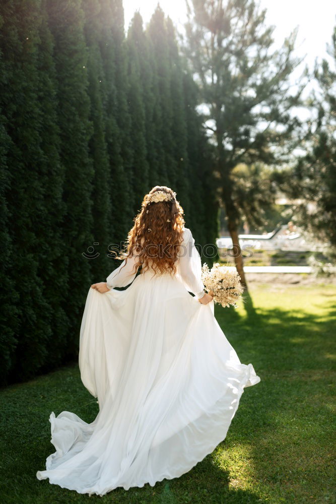 Similar – Image, Stock Photo Girl in the garden with long white dress. She stands with her back to the camera, in front of her are green bushes and shrubs.