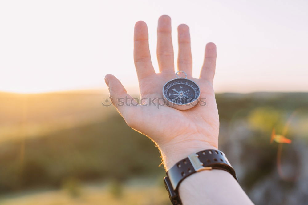 Similar – Image, Stock Photo Hand with compass at mountain road at blue sky