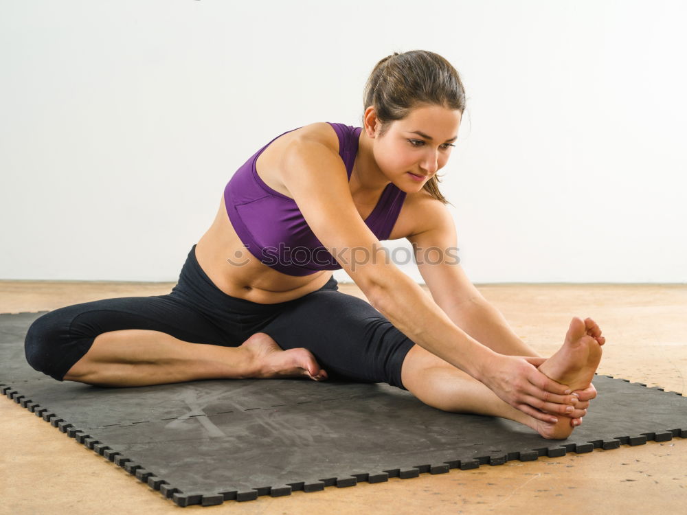 Similar – Group of young sporty attractive women in yoga studio, practicing yoga lesson with instructor, sitting on floor in forward bend yoga sana posture. Healthy active lifestyle, working out indoors in gym