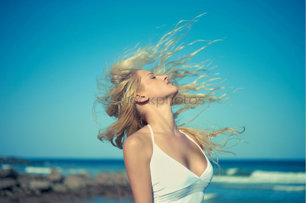 Similar – Cute woman touching her hair while the wind moves it.