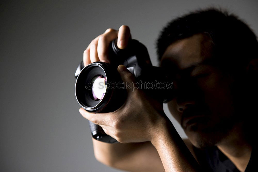 Similar – Bearded man dressed in blue t-shirt with binoculars posing against black background