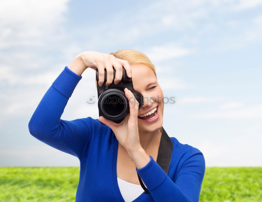 Similar – Smiling young woman using a camera to take photo at the park.