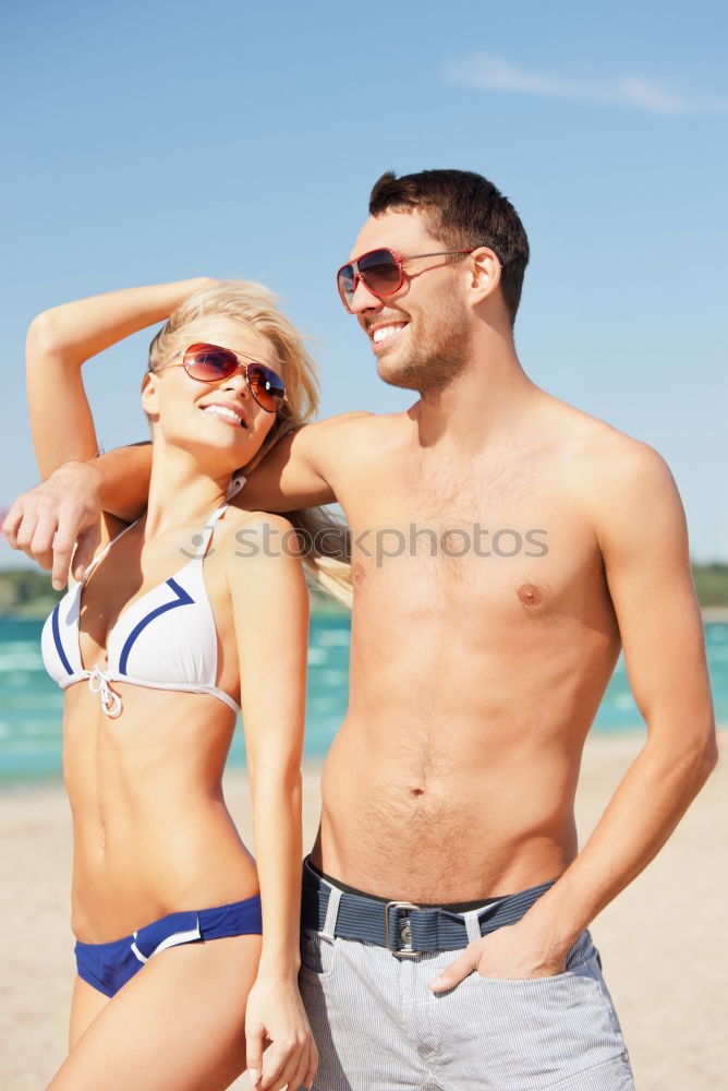 Close-up of young adult’s muscular bodies on the beach