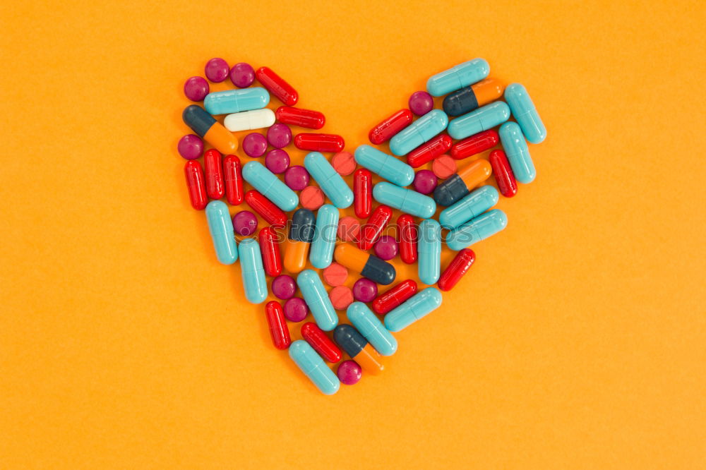 Image, Stock Photo Pills arranged in heart shape on an orange background