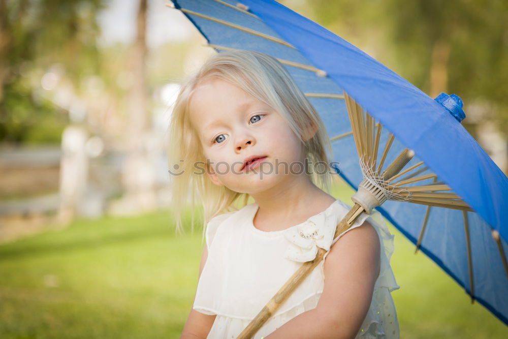 Similar – happy kid girl hiding under umbrella