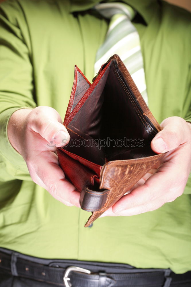 Similar – two female hands hold brown leather open empty wallet for cash