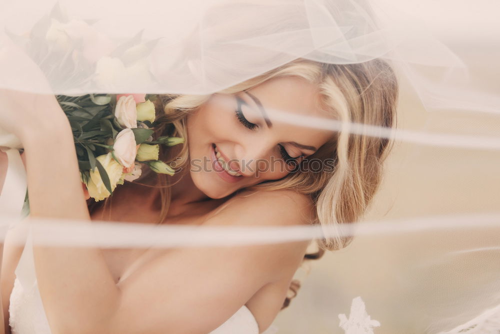 beautiful young woman with long flowing blond hair examines white wedding dress