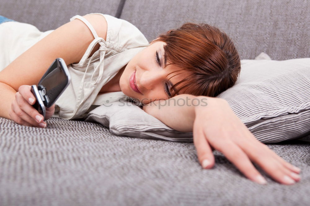 Similar – Young girl looking at mobile phone while sitting on bed