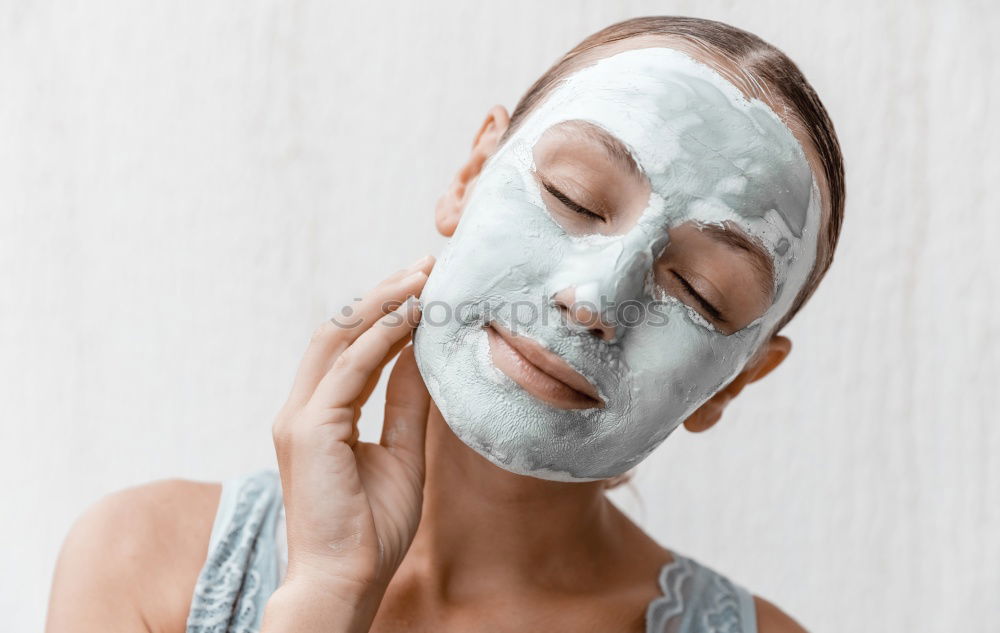 Image, Stock Photo Woman with bathrobe and towel on her head enjoys a face mask and holds two slices of cucumber in front of her eyes. Wellness, face care.