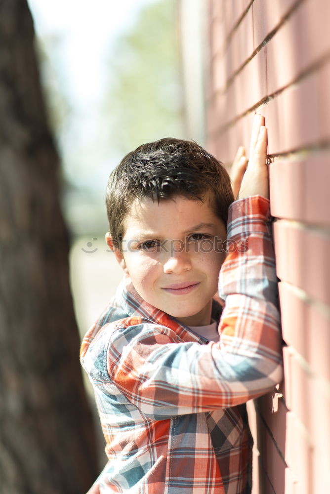 Similar – Little boy with a mibile phone with a wooden door background