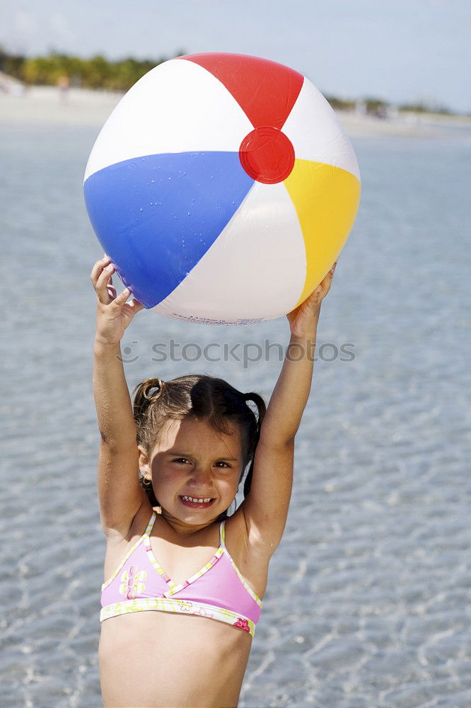 Similar – little girl stands on beach in a special swimsuit for children who can not swim. child in swimsuit, which he kept afloat